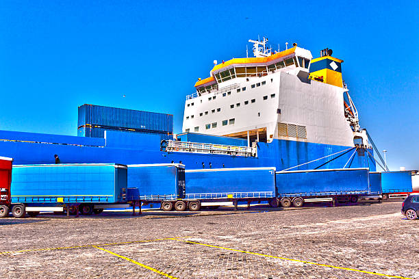 a blue and yellow cargo ship anchored at the port