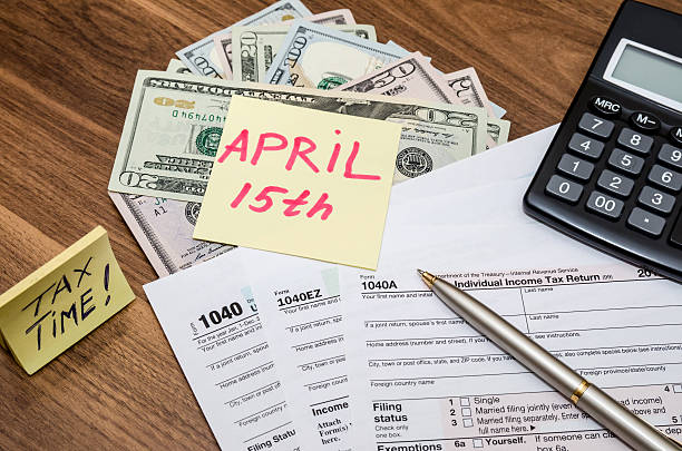 istock 1040 tax form with stick april 15,  dollar  and calculator 512226800