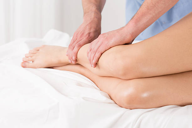Physical therapist doing lymphatic drainage Physical therapist doing lymphatic drainage for the legs drainage photos stock pictures, royalty-free photos & images