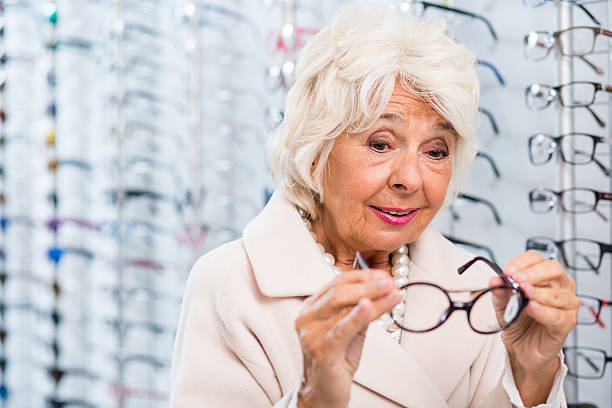 istock Senior woman trying on eyeglasses 512228484