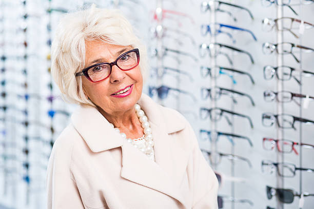istock Elder woman trying on glasses 512228496