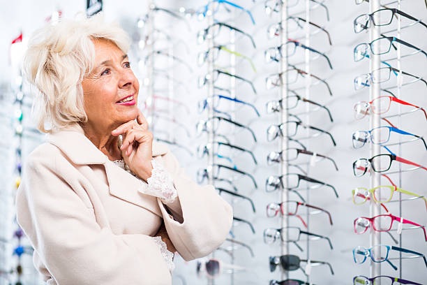 istock Elderly woman at optical shop 512229280