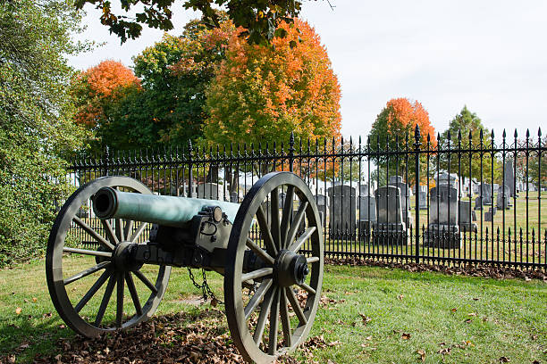 Gettysburg Cannon with Cemetery Gettysburg cannon in autumn  gettysburg national cemetery stock pictures, royalty-free photos & images