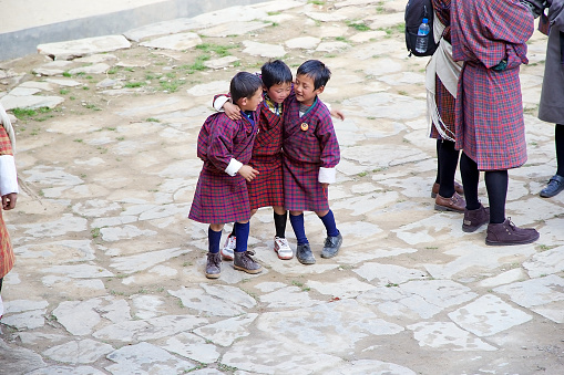 Gangten, Bhutan - November 11, 2015: Bhutanese children in traditional clothes are attending at the ceremony during the Black-necked crane Festival at the Gangtey Monastery also known as Gantey Gompa, Gangten, Bhutan. Gangtey Monastery is an important monastery of Nyingmapa school of Buddhism. The monastery's history date back to 17th century and back to the prophecies made by pema Lingpa in the 15th century.