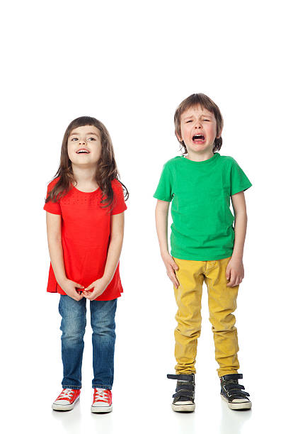 Smiling and crying Image of smiling girl and crying boy, isolated on white sad child standing stock pictures, royalty-free photos & images