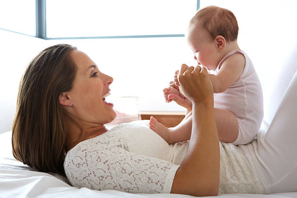 istock Beautiful mother smiling with baby in bed 512248833