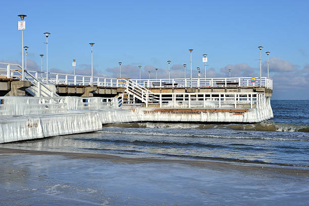 istock Wooden jetty covered with snow over a sea with ice 512249733