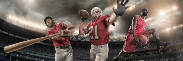 Composite image of three male athletes in action from waist up depicting three sports – baseball player hitting baseball. American football player about to throw ball, basketball player jumping. Backgrounds are the floodlit stadiums and arenas appropriate to each sport under stormy cloudy skies. All players are wearing generic sports kit. 