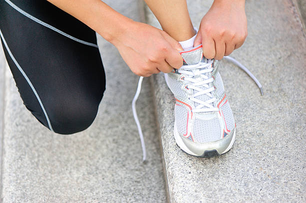 istock woman runner  tying  shoelace 512250979