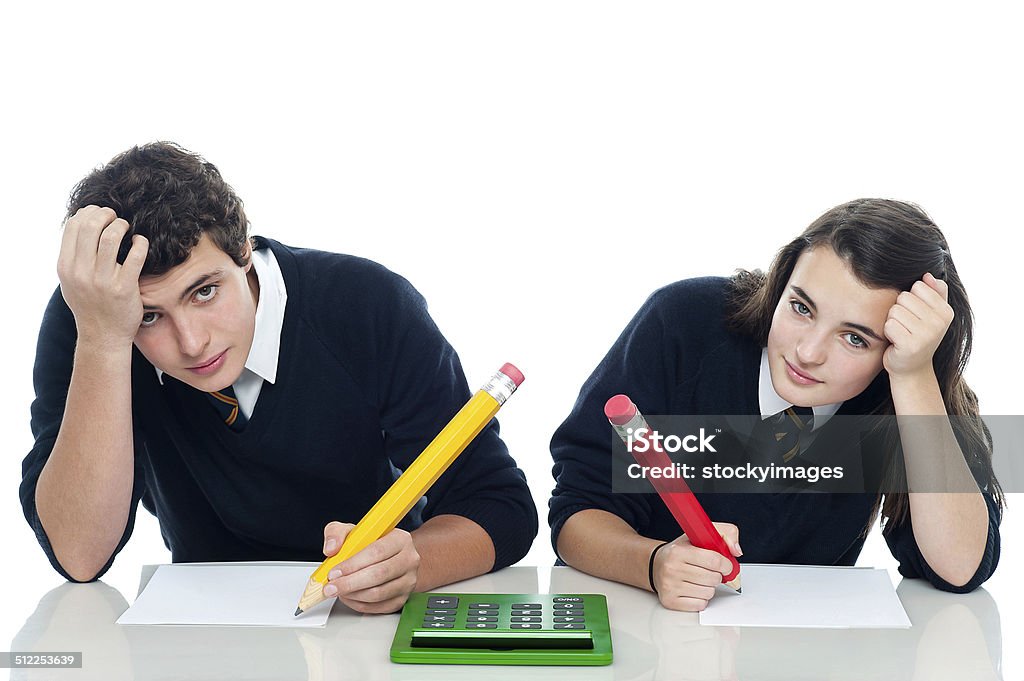 Confused students holding their heads during examination Confused students holding their heads during examination. Trying to recollect the answer Beautiful People Stock Photo