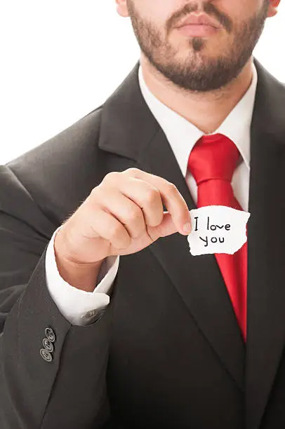 Love statement concept Using I Love You text written on a paper held by an elegant man