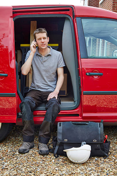 istock Tradesman sitting in van talking on cell phone 512254363