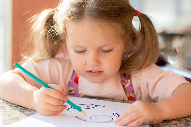 istock Child draws with a pencil and smiles. 512272018