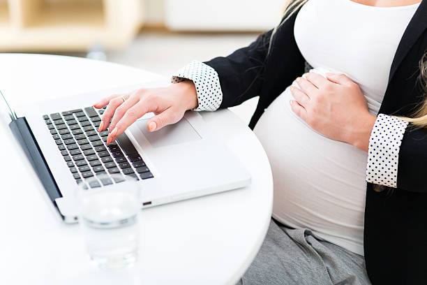 istock Pregnant woman at work using laptop 512272731