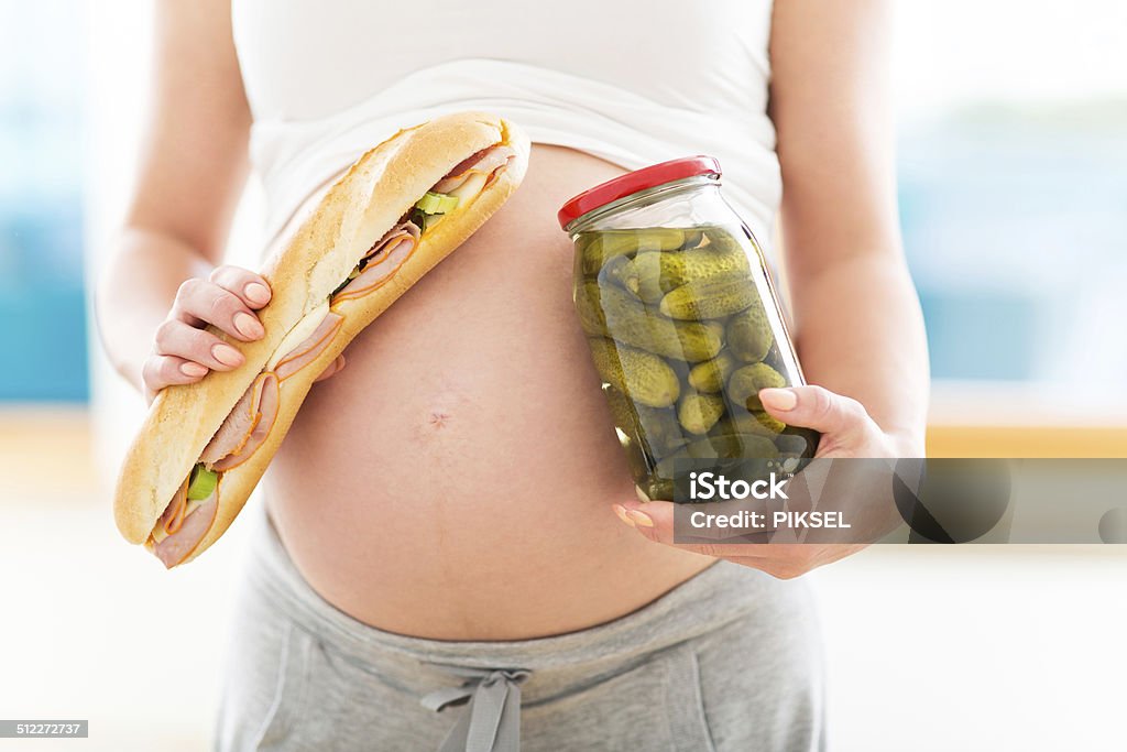 Pregnant woman with sandwich and jar of pickles Holding Stock Photo