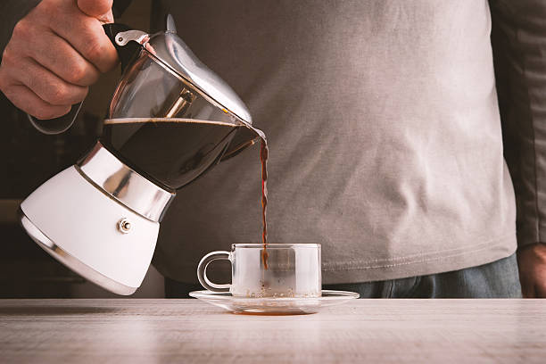 istock Man pouring coffee into a glass cup horizontal 512272906