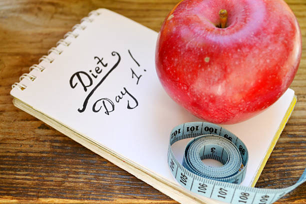 istock Diet concept with red apple, notebook and blue measuring tape 512273771