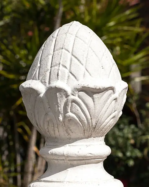 Photo of Decorative White Concrete Pineapple Fence Post in Sunlight
