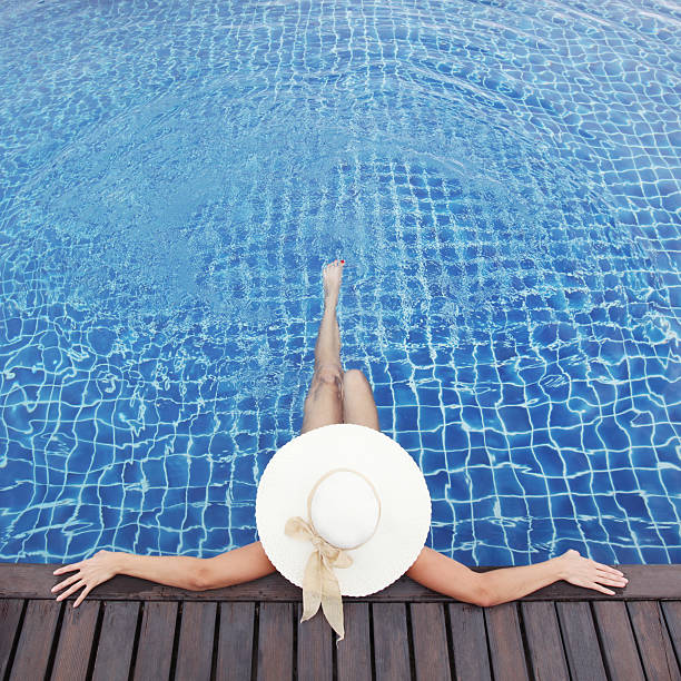 istock Woman in hat relaxing at pool 512274978