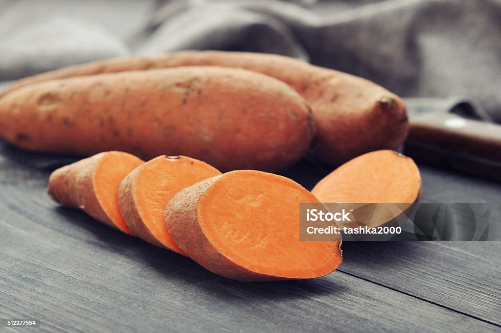 Raw sweet potatoes Raw sweet potatoes on wooden background closeup Agriculture Stock Photo