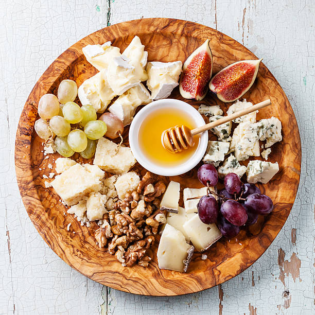 Cheese plate Cheese plate Assortment of various types of cheese on olive wood plate plate fig blue cheese cheese stock pictures, royalty-free photos & images
