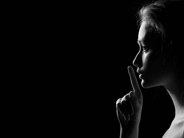 mujer muestra silencio - finger on lips whispering secrecy women fotografías e imágenes de stock