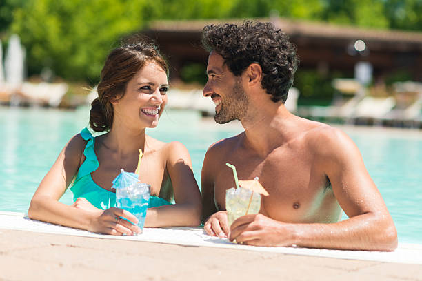 istock Couple enjoying a cocktail on the poolside 512280176