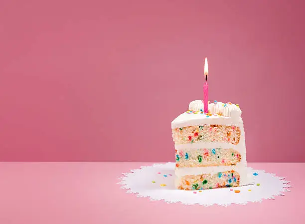 Photo of Slice of Birthday Cake with Candle on Pink
