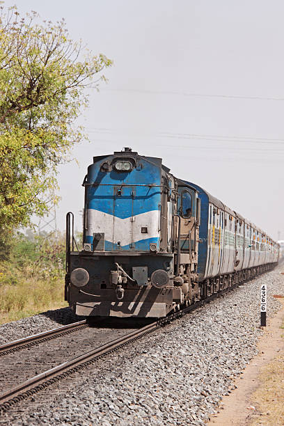 Passenger train bound for Ahmedabad passing through rural Rajasthan, India Express train bound for Ahmedabad passing through rural Rajasthan near the city of Pali india train stock pictures, royalty-free photos & images