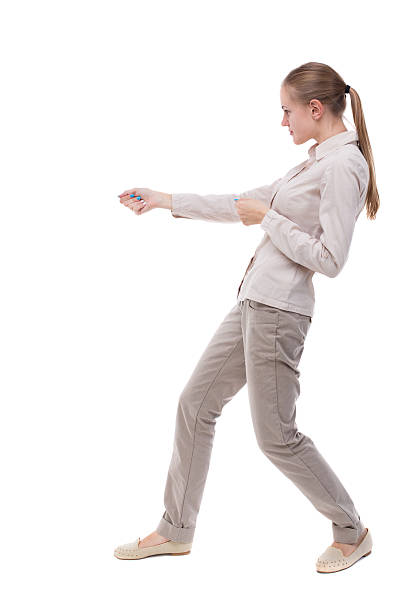 istock back view of standing girl pulling a rope from top 512287304