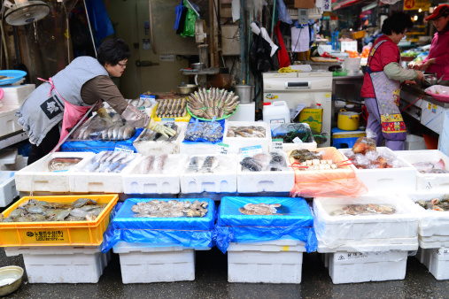 Seoul, South Korea - April 16, 2014: Hawker sells fish in the Namdaemun market. Namdaemun Market, located in the center of Seoul, is the biggest traditional market in Korea.