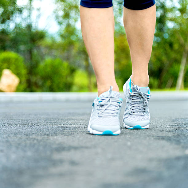 istock Woman's running shoes on asphalt road 512289712