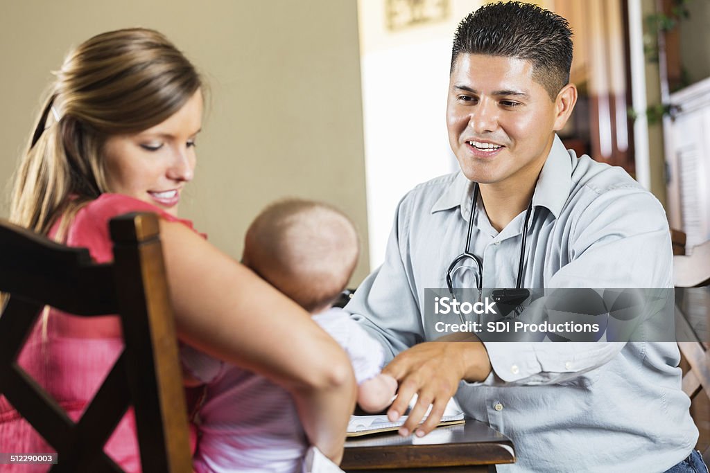 Mother and peidatrician examining young baby with cystic fibrosis Adult Stock Photo