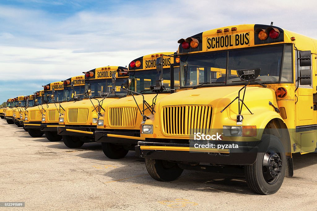 school buses row of yellow school buses lined up in a parking lot School Bus Stock Photo