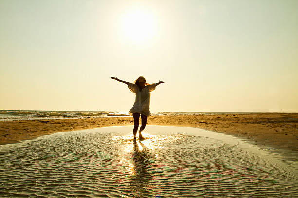 istock Beautiful Woman dancing on the beach 512291903