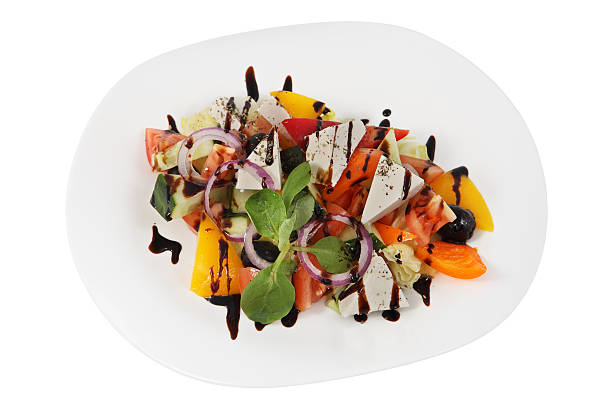 istock Cold starter, Greek salad on white plate, studio shot, isolated. 512292386