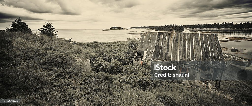 Seaside Shanty An abandoned seaside home is overtaken by the landscape.  Toned black and white. Abandoned Stock Photo