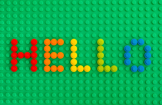 Tambov, Russian Federation - January 24, 2016: Word Hello spell out from Lego Round Bricks 1x1 on green baseplate. Studio shot.
