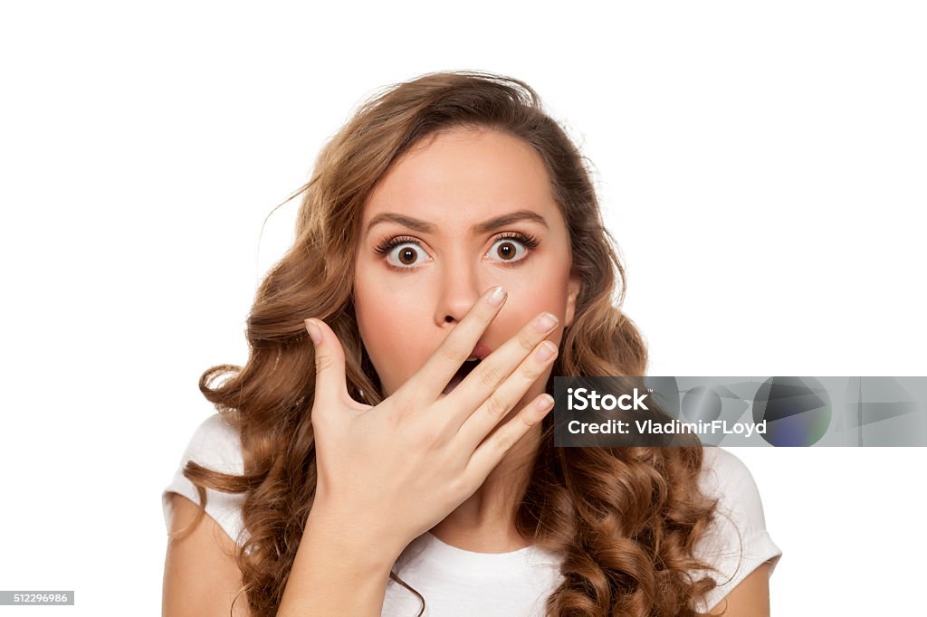 shocked woman beautiful and shocked young woman holding her hand over her mouth on white background Surprise Stock Photo