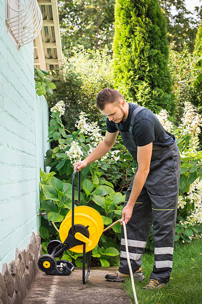 Gardener with a hose for watering