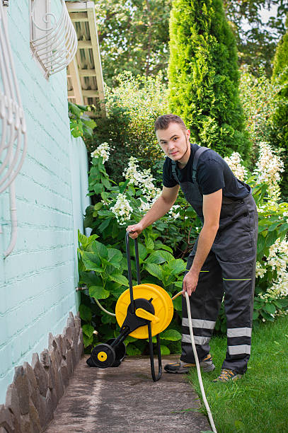 istock Gardener with a hose for watering 512301820