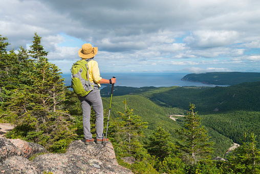 Woman hiking at the top of mountain in Cape Breton Highlands National Park, Cabot Trail in Nova Scotia, Canada, Maritime provinces.