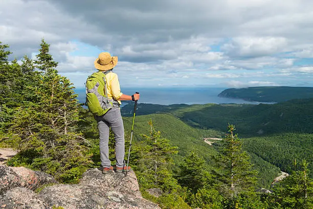 Woman hiking at the top of mountain in Cape Breton Highlands National Park, Cabot Trail in Nova Scotia, Canada, Maritime provinces.