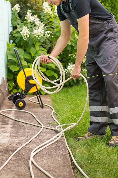 istock Gardener with a hose for watering 512302720