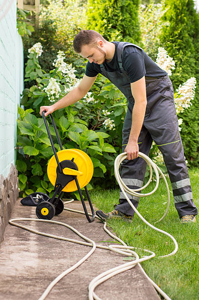 istock Gardener with a hose for watering 512302784