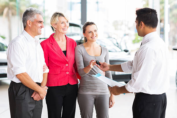 istock salesman handing over car key to customer 512308609