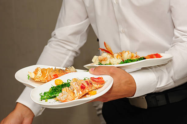 istock Waiter holds plates with lobsters 512309047