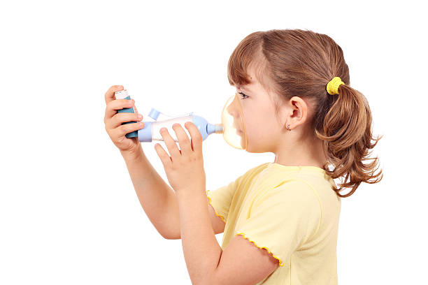 little girl with asthma inhaler stock photo