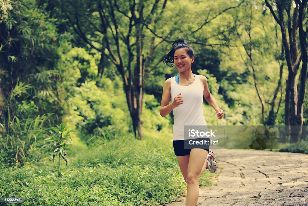 Runner athlete running on forest trail. Runner athlete running on stone forest  trail. woman fitness jogging workout wellness concept. Activity Stock Photo