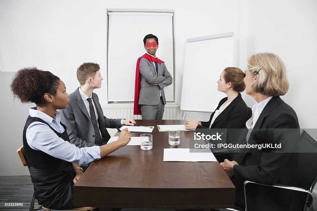Business person in the office Business leader as superhero in front of colleagues at meeting in conference room African Ethnicity Stock Photo